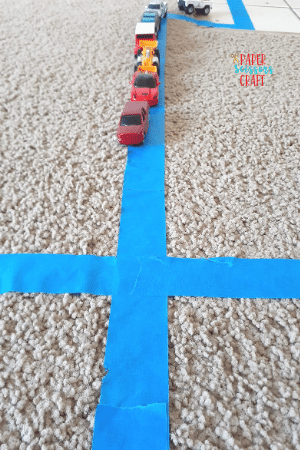 Masking tape road with toy cars on it.