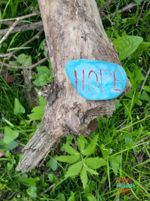Example of rock painting with a blue painted rock that has the word hope painted on it.