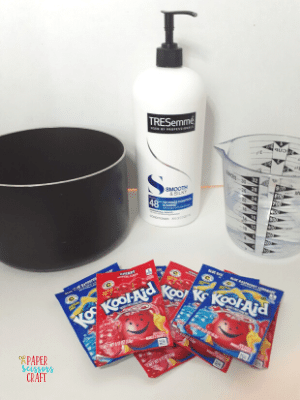 Pot, conditioner, measuring cup, and Kool-Aid packets all on a counter.