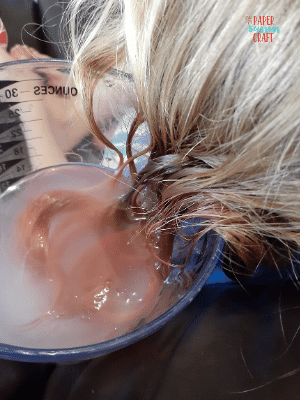 Kool-Aid dyed hair being placed in a baking soda and hot water mixture.