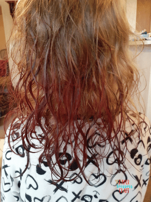 Back of a little girl's head that is wet and has been dyed with Kool-Aid.
