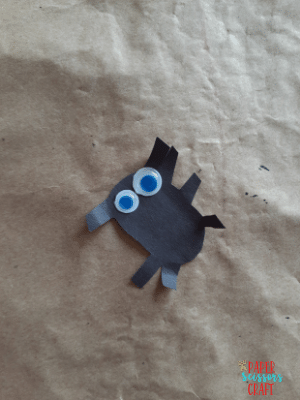 Black construction paper spider with googly eyes.