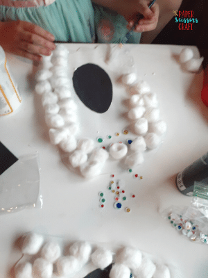 Cotton ball ghost craft showing how to add cotton balls.