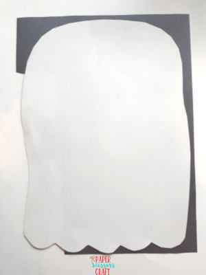 Ghost cutout on top of black construction paper.