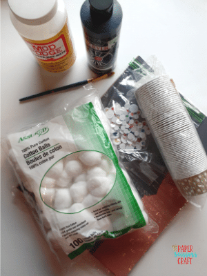 Supplies needed to make cotton ball ghosts.