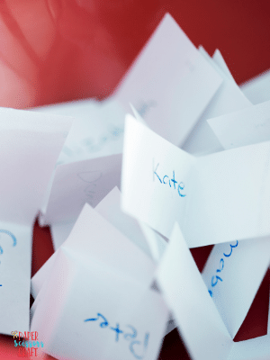 Small folded sheets of paper with names written on them.