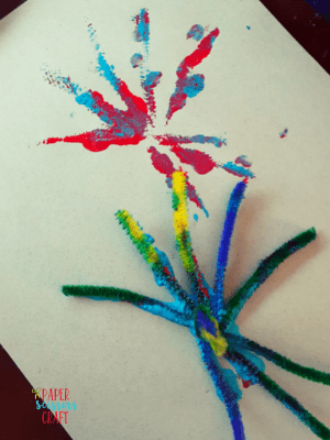Example of how to create a firework on paper with paint and a pipe cleaner.