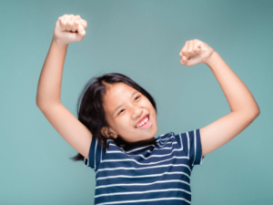 Child that is happy with arms above her head.